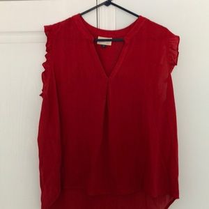 Red sleeveless blouse with ruffled arms.